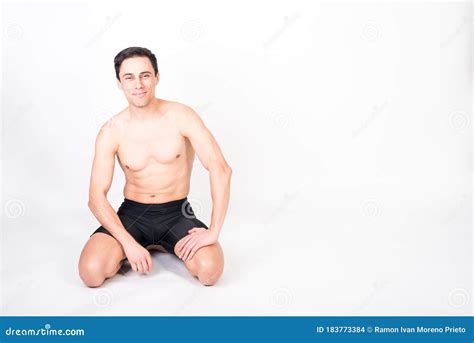 Shirtless Athlete Man Kneeling On The Floor Looking At Camera Smiling