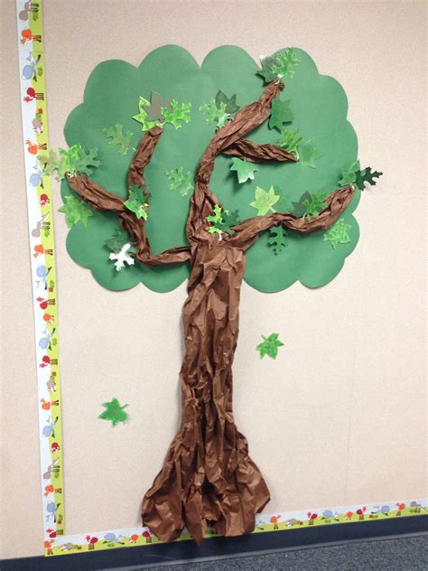 A Tree Made Out Of Brown Paper With Green Leaves And Stars On The