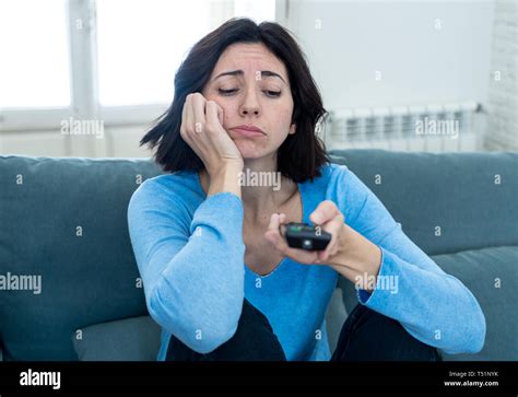 Young Upset Woman On Sofa Using Control Remote Zapping Bored Of Bad Tv