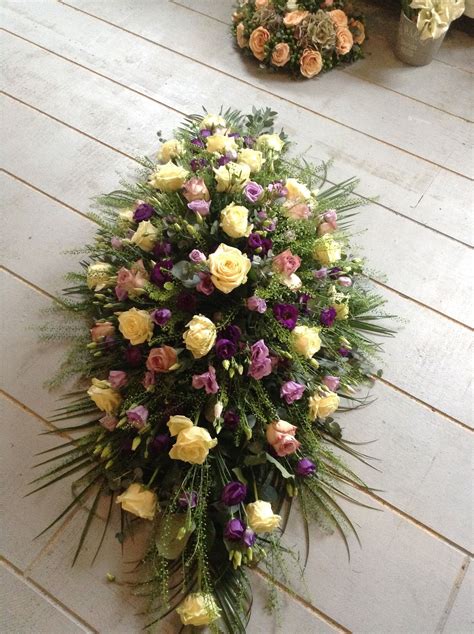 Flowers are a touching gift to send to family or friends who have recently lost a man in their life. cream and purple funeral flowers, coffin spray, casket ...