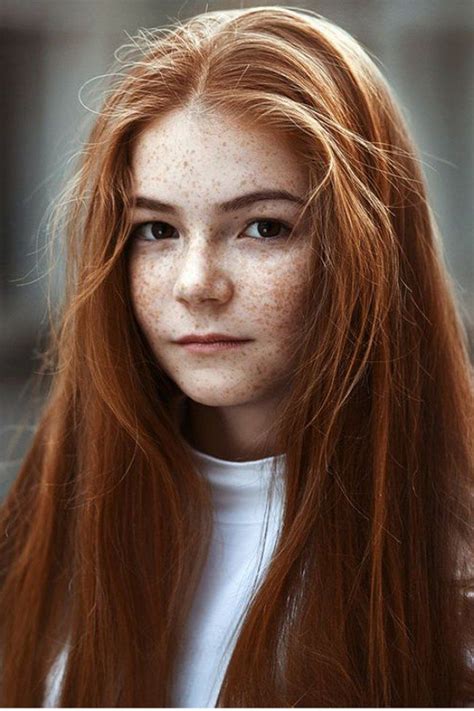 A Woman With Freckled Red Hair Is Looking At The Camera