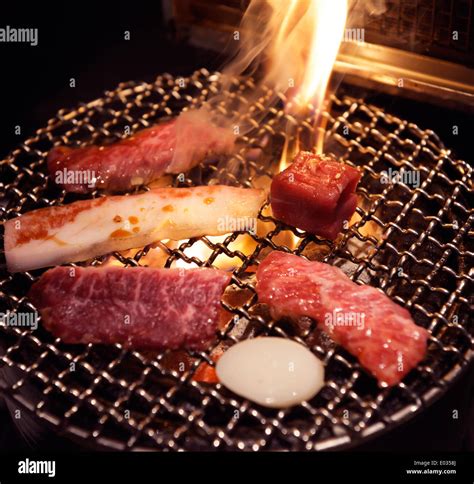Meat On Grill Being Cooked On Fire At A Japanese Grill Restaurant