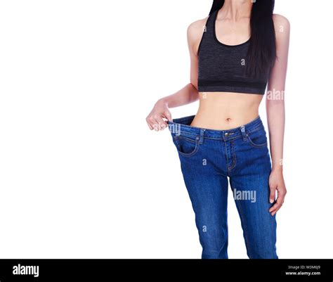 Close Up Of Woman Show Her Weight Loss And Wearing Her Old Jeans Isolated On A White Background