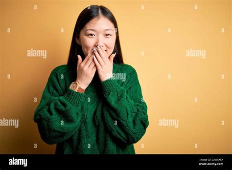 Young Beautiful Asian Woman Wearing Green Winter Sweater Over Yellow Isolated Background