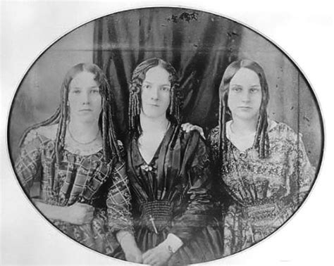 An Old Photo Of Three Women With Long Braids On Their Heads And Shoulders Standing Next To Each