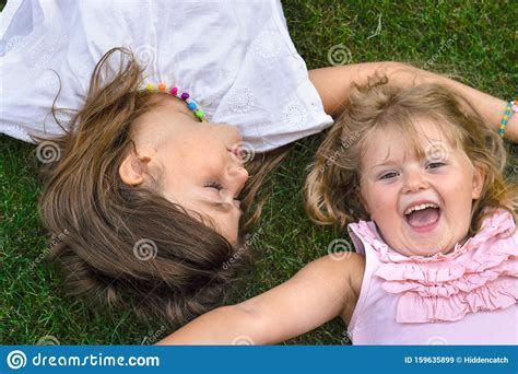 Twee Kleine Meisjes Die Op Het Gras Liggen Lachen En Plezier Hebben