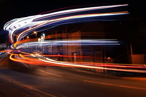 Photograph Of The Light Trails From A Bus Driving Around The Bend In
