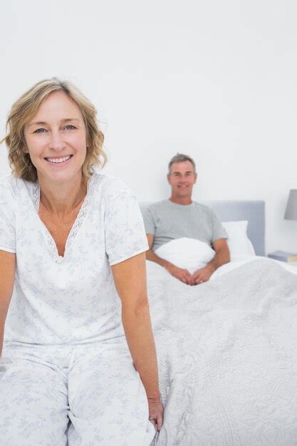 Premium Photo Smiling Couple Sitting On Opposite Ends Of Bed