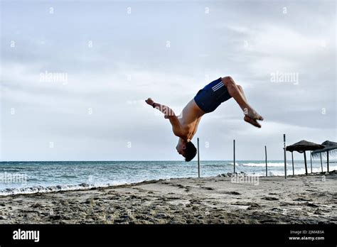 Young Man Doing Backflips Somersaults In The Sand Stock Photo Alamy