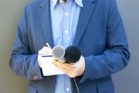 Reporter At Media Event Or News Conference Holding Microphone Writing