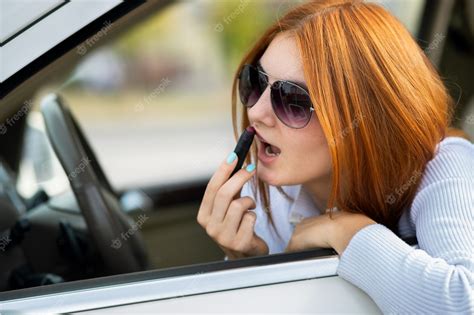Premium Photo Closeup Of A Young Redhead Woman Driver Correcting Her
