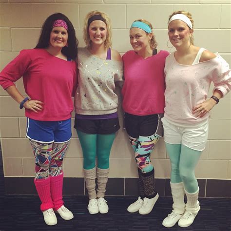 Three Women In Pink Shirts And Colorful Leggings Posing For A Photo