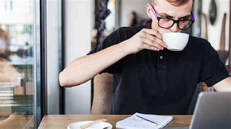 Trinkender Kaffee Des Mannes Am Tisch Mit Laptop Kostenlose Foto