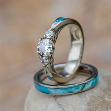 Two Wedding Rings Sitting On Top Of Each Other With Turquoise Stones In The Foreground