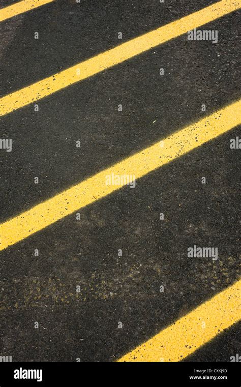 Black Asphalt Pavement Painted With Yellow Stripes In A Diagonal Lines