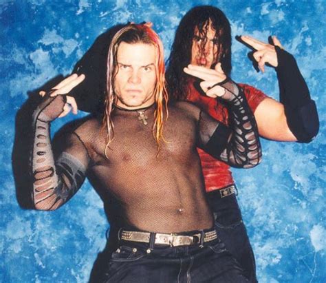 Two Men With Long Hair And No Shirt On Posing In Front Of A Blue Background