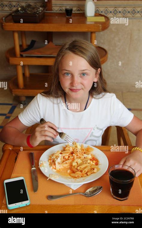 Modern Child Eating Lunch With Macaroni With Sauce At Restaurant