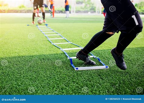 Young Boy Soccer Players Jogging And Jump Between Ladder Drills For