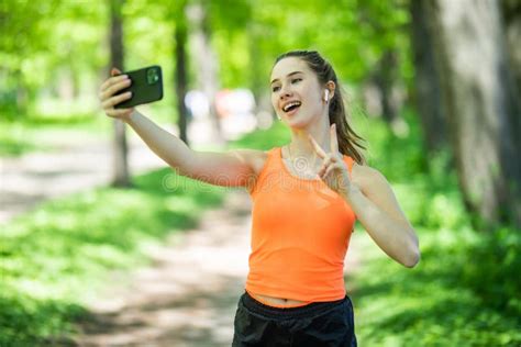 Selfie Portrait Young Cheerful Fit Woman In Sports Top Smiling Outdoors