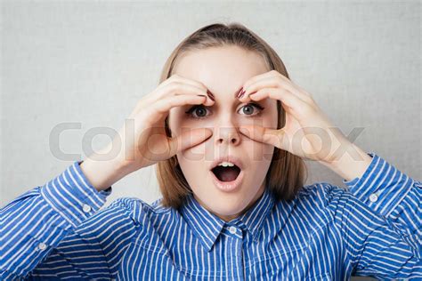 Serious Woman With Hand Over Eyes Looking Through Fingers Stock