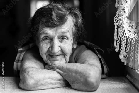 Granny Is Sitting Near The Window In The Kitchen Black And White