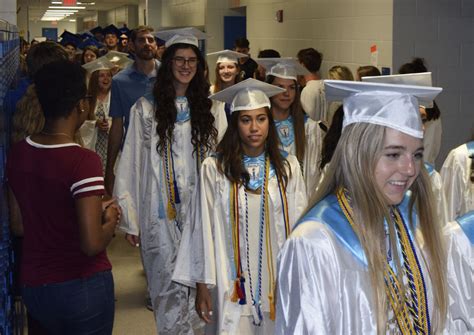 seniors march in caps and gowns warrior record online