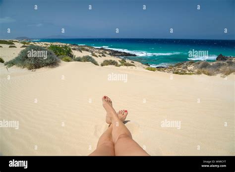 Woman Legs Lying On A Beautiful Tropical Beach Near The Ocean Barefoot