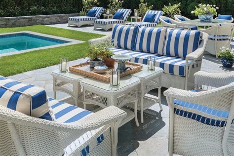 Teak's warm, rich color draws guests into your home and invites them to relax and stay a while. Summer blues + stripes + wicker for the win! This outdoor space by Mark D. Sikes is ready for it ...