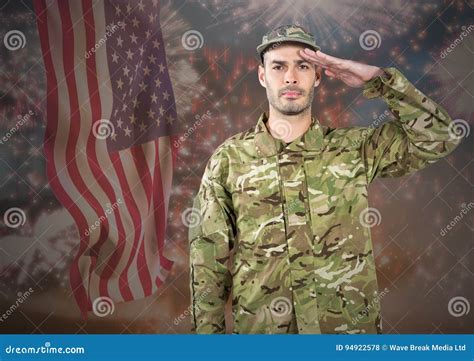 Proud Soldier Saluting Against Fluttering American Flag And Fireworks