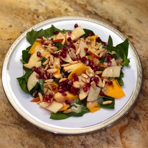 Persimmon Pomegranate Salad Over Baby Spinach Leaves With Tangy Honey