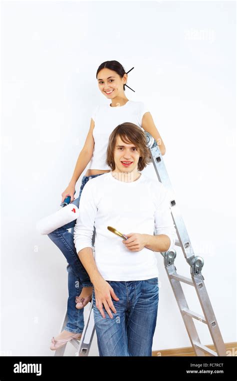 Young Couple With Paint Brushes Doing Renovation Together Stock Photo