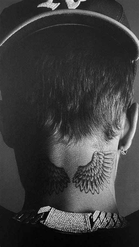 The Back Of A Mans Head With Tattoos On His Neck And Shoulders