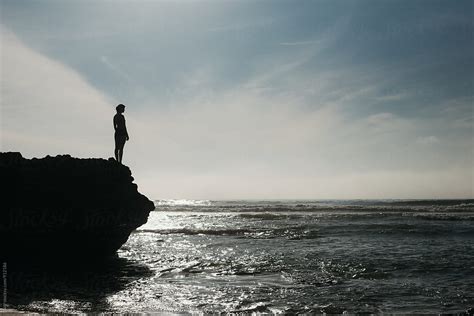 Girl Watching The Ocean Waves From A Rock Above In The Summertime Del