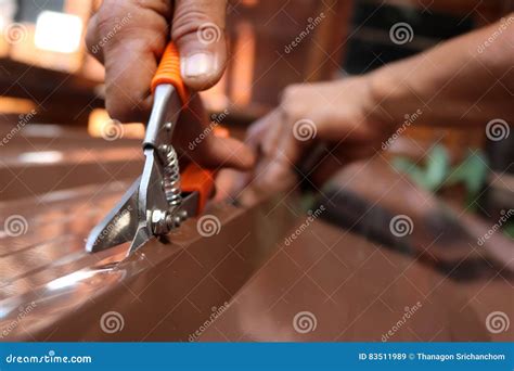 Workers Use Scissors To Cut The Metal Sheet For Roofing Stock Image