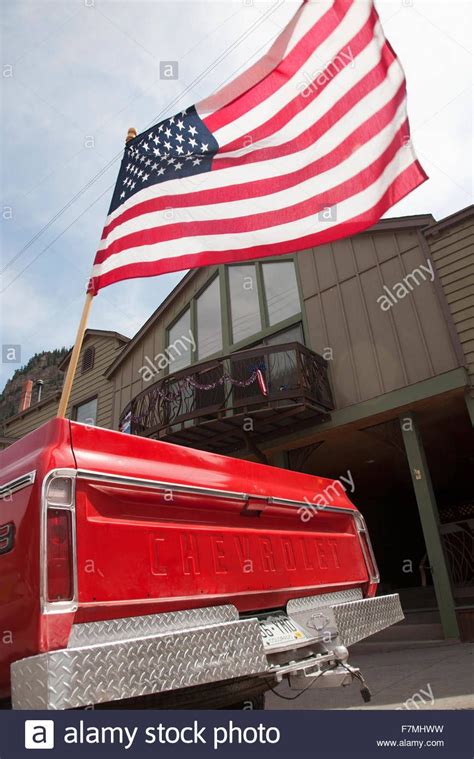 us flag flies over old red chevrolet pickup truck july 4 independence day parade ouray
