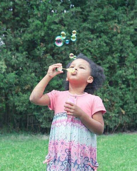 Girl Blowing Bubbles Outdoors Stock Photo Dissolve