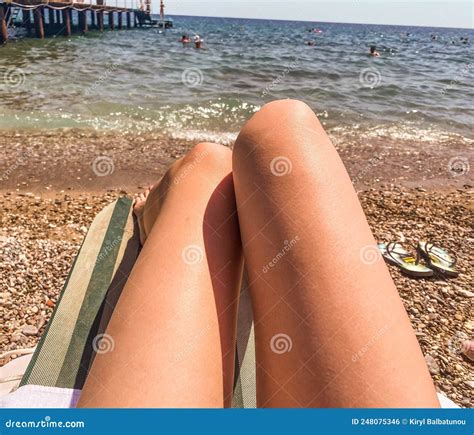 The Girl Is Resting On A Sunbed Made Of Fabric Sunbathing Under The