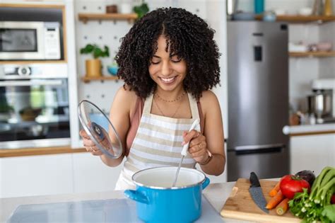 Premium Photo Happy African American Woman Cooking Tasting Dinner In