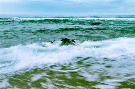 Waves Rushing To Shore Over A Large Boulder Stock Photo Image Of