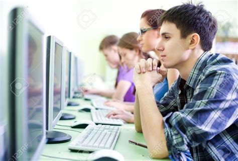 15120851 Group Of Teens In Internet Cafe With Computers Stock Photo