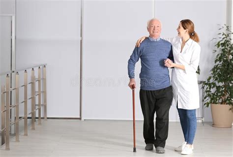 Elderly Man With Female Caregiver Indoors Stock Image Image Of Full