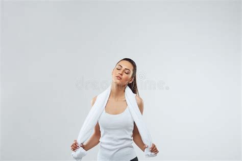 beautiful strong woman with towel on her shoulders fitness girl model isolated on grey