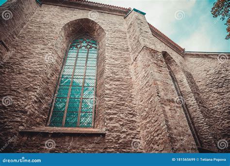 Gothic Style Ornate Window And Gray Brick Wall Of The Church Medieval