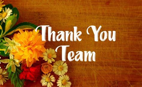 A Thank You Team Card With Yellow And Red Flowers On A Wooden Surface