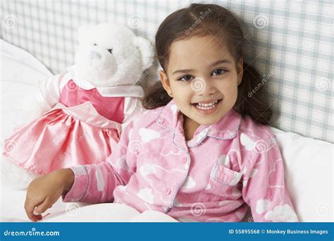 在床阅读书的女孩佩带的睡衣 库存照片 图片 包括有 微笑 种族 愉快 户内 玩具 一个 故事 55895568