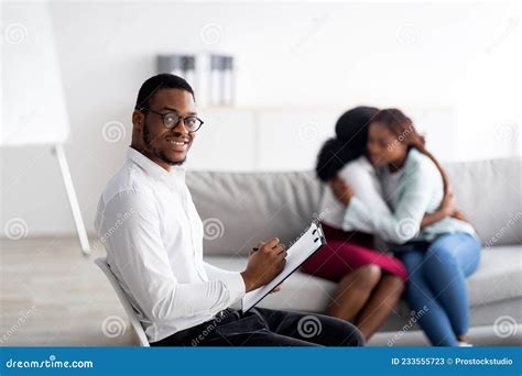 Male Psychologist Smiling While Black Lesbian Couple Hugging At Office Reconciling And Solving