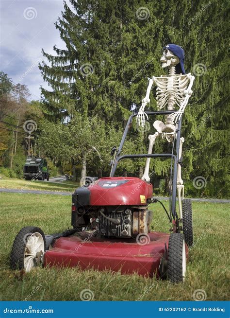 Funny Skeleton Wearing A Baseball Cap Pushing A Lawnmower Stock Photo