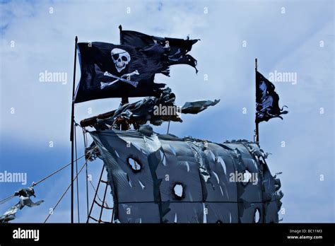 Pirate Flags Above Tattered Sails Stock Photo Alamy