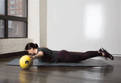 A Woman Is Doing Push Ups With A Medicine Ball