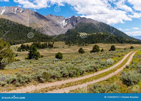 Two Path Dirt Road Leads Through The High Rocky Mountains Of Idaho
